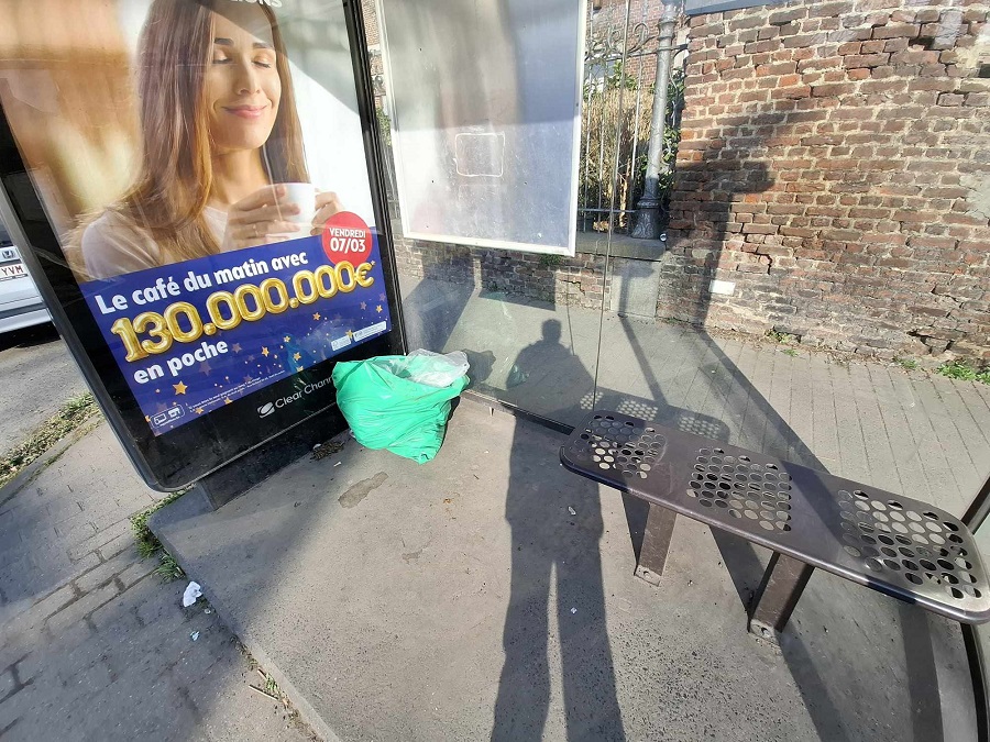 Déchets : Sac poubelle vert dans un abri bus