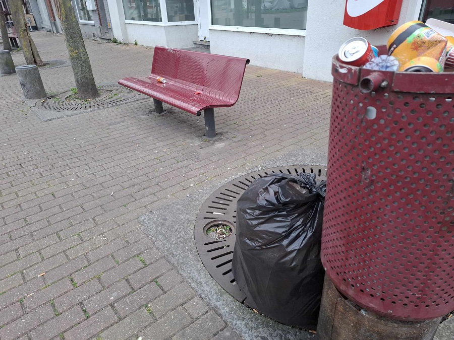 Poubelle débordante de déchets et sac poubelle noire