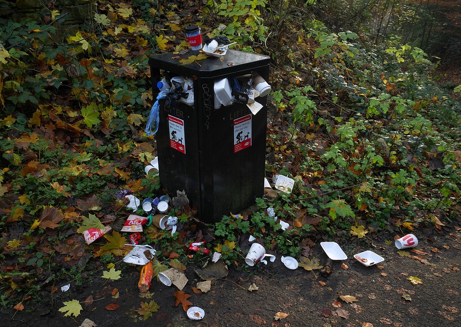 Déchets dans une poubelle publique et aux alentours de celle-ci