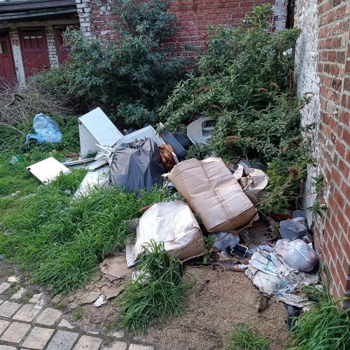 Nombreux déchets ménagers et cartons jetés dans la cour d'une résidenc Nombreux déchets ménagers et cartons jetés dans la cour d'une résidenc