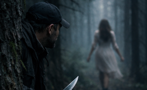 Dans une forêt, un homme, armé d'un couteau, traque une femme